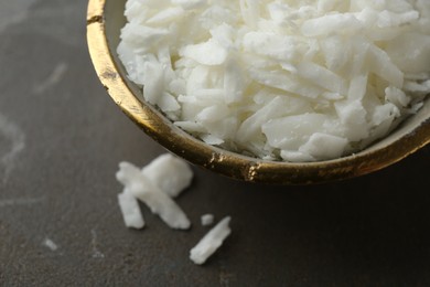 Photo of Soy wax in bowl on grey table, closeup