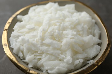 Soy wax in bowl on grey table, closeup