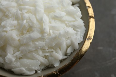 Soy wax in bowl on grey table, closeup