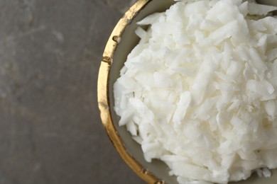 Photo of Soy wax in bowl on grey table, top view. Space for text