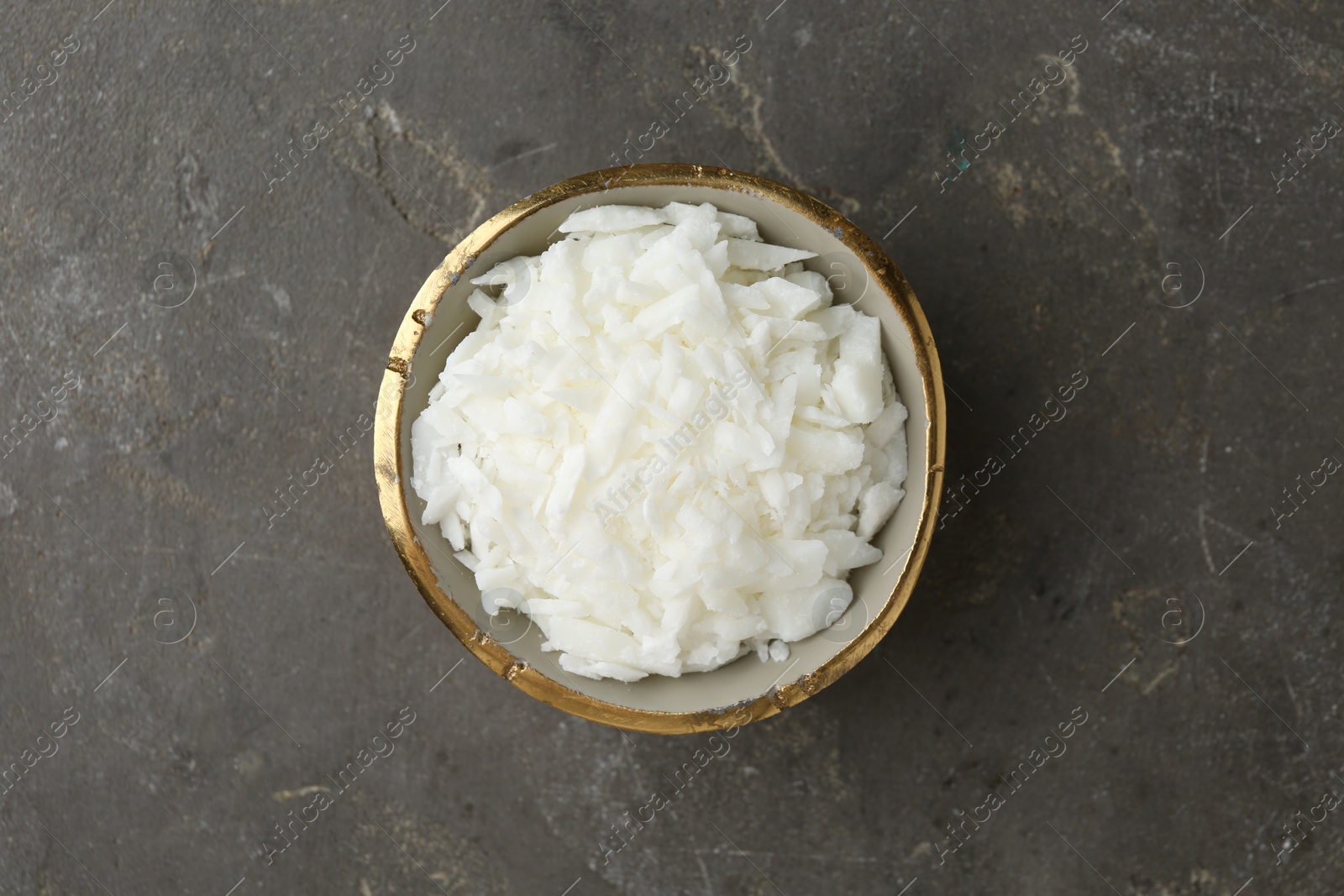 Photo of Soy wax in bowl on grey table, top view