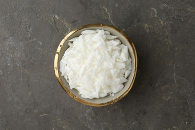 Soy wax in bowl on grey table, top view