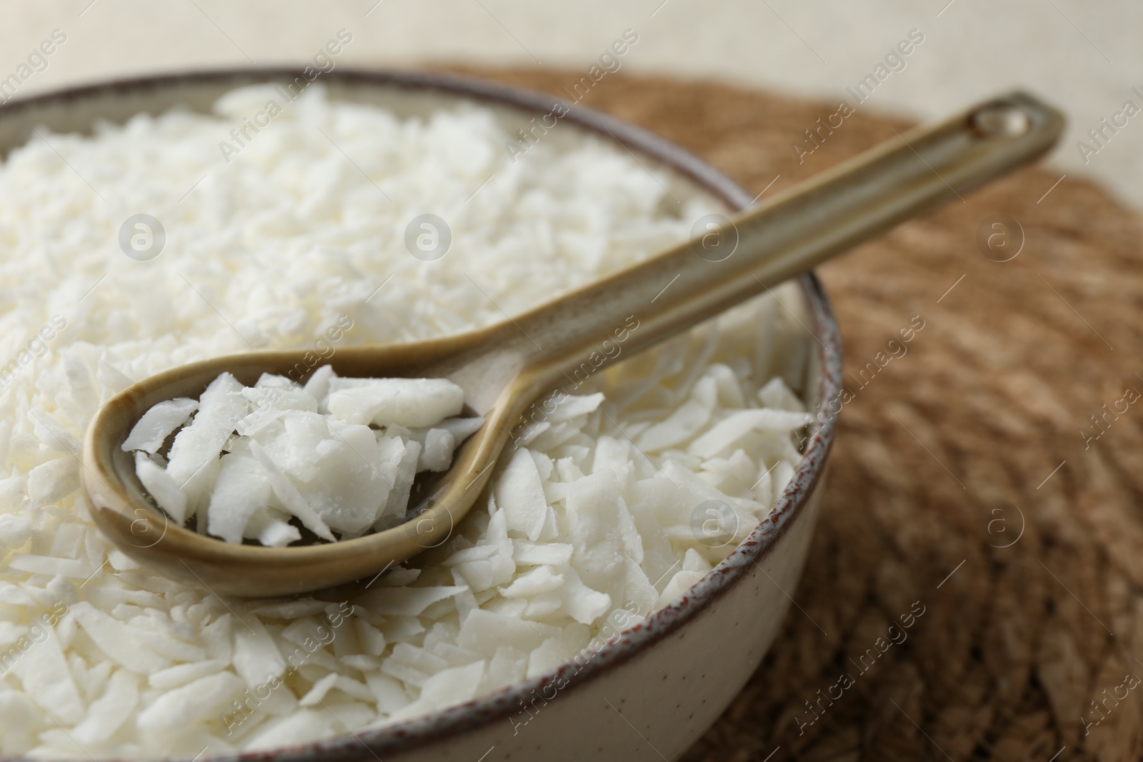 Photo of Soy wax in bowl on wicker mat, closeup