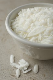 Photo of Soy wax in bowl on light grey table, closeup