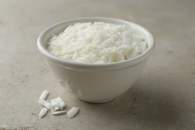 Soy wax in bowl on light grey table, closeup