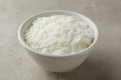 Soy wax in bowl on light grey table, closeup