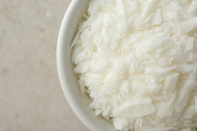 Photo of Soy wax in bowl on light grey table, top view