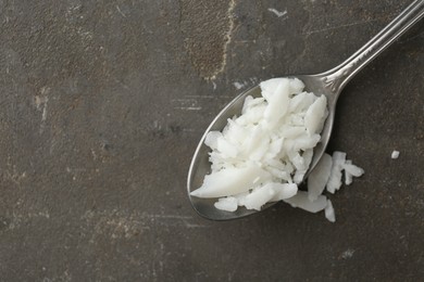 Soy wax in spoon on grey table, top view