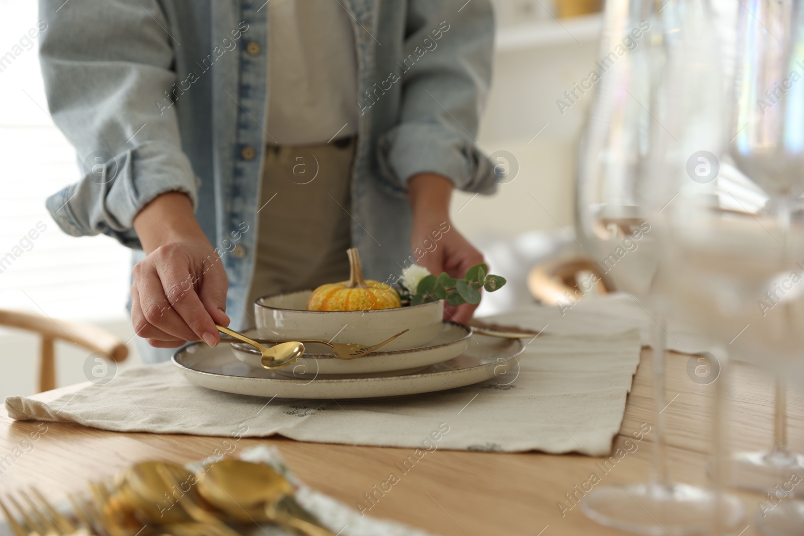 Photo of Woman setting table for dinner at home, closeup