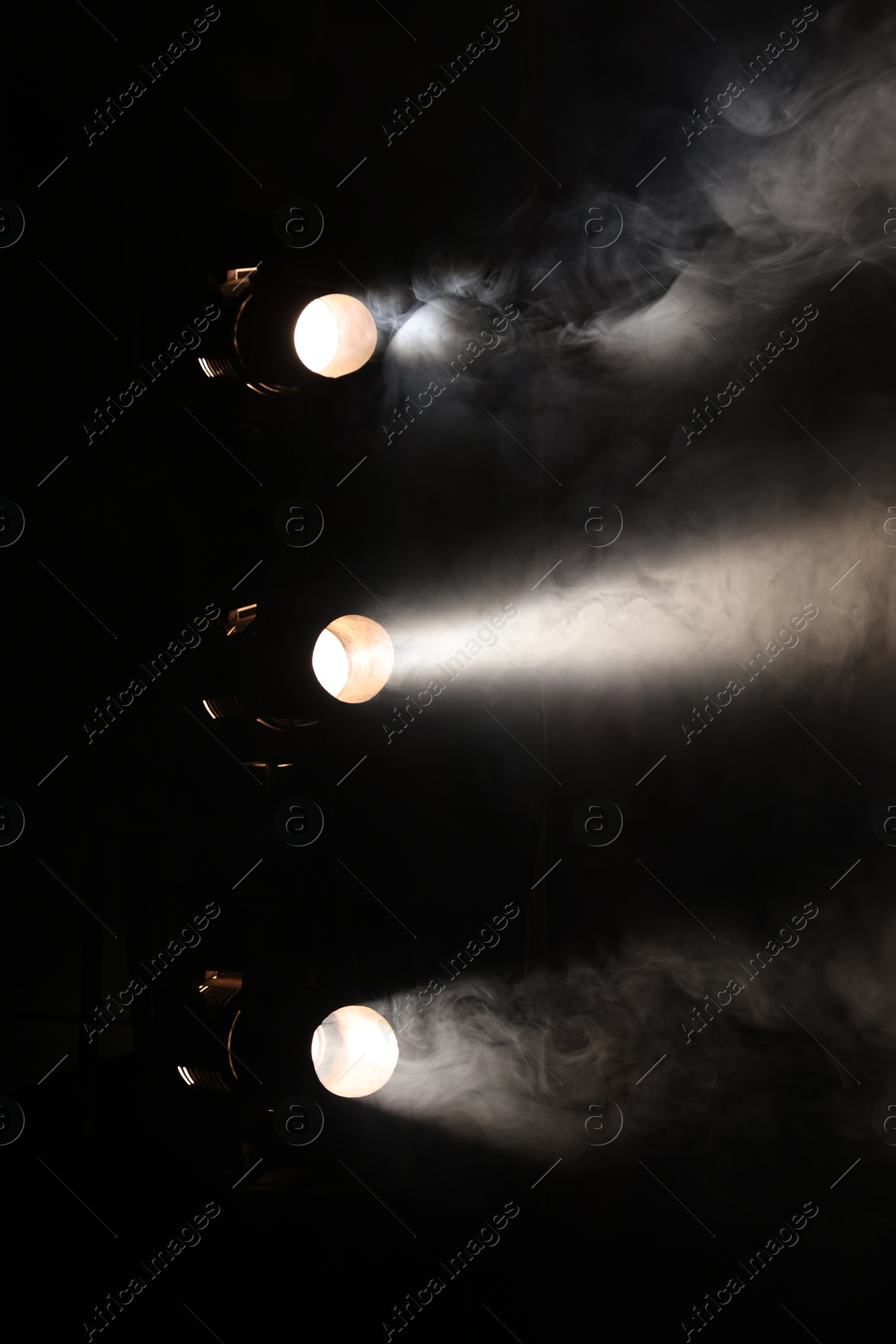 Photo of Professional spotlights and smoke on stage in theatre