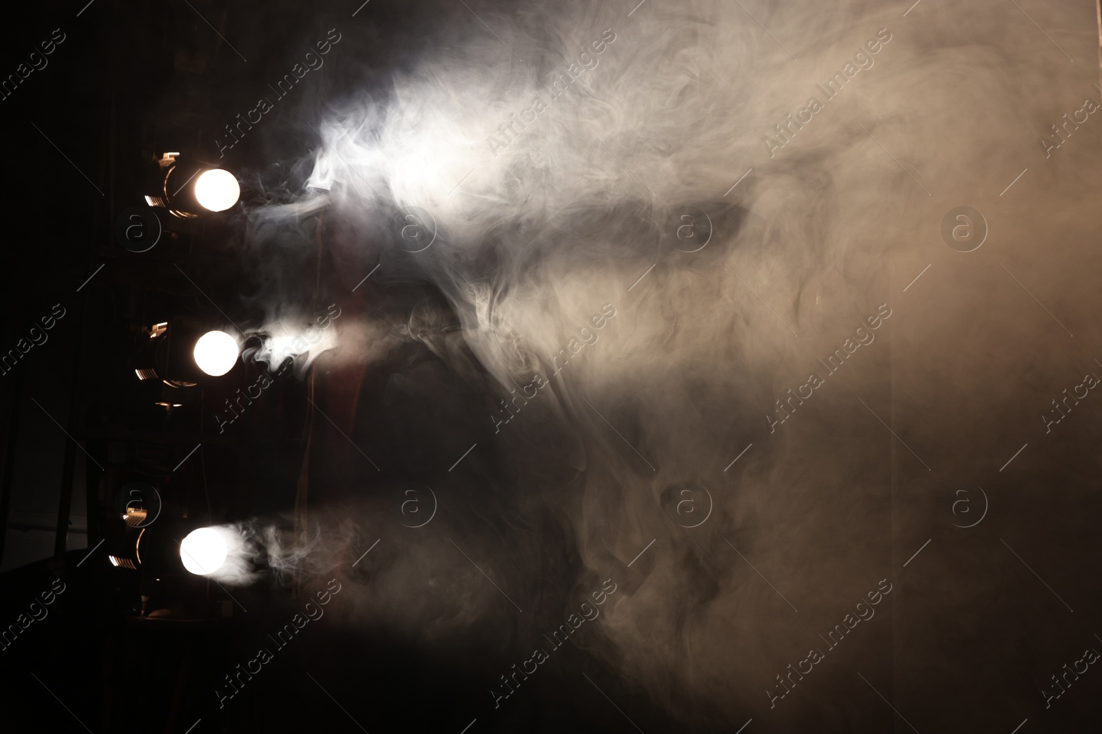 Photo of Professional spotlights and smoke on stage in theatre