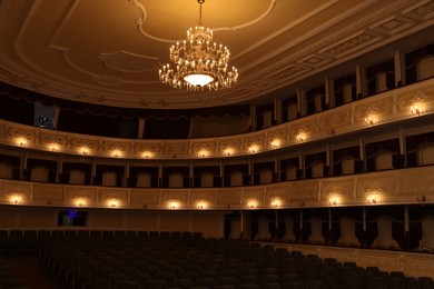 Photo of Rows of comfortable seats and beautiful chandelier in theatre