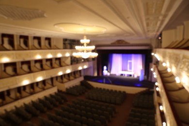 Photo of Theatre interior with stage, rows of comfortable seats and beautiful chandelier