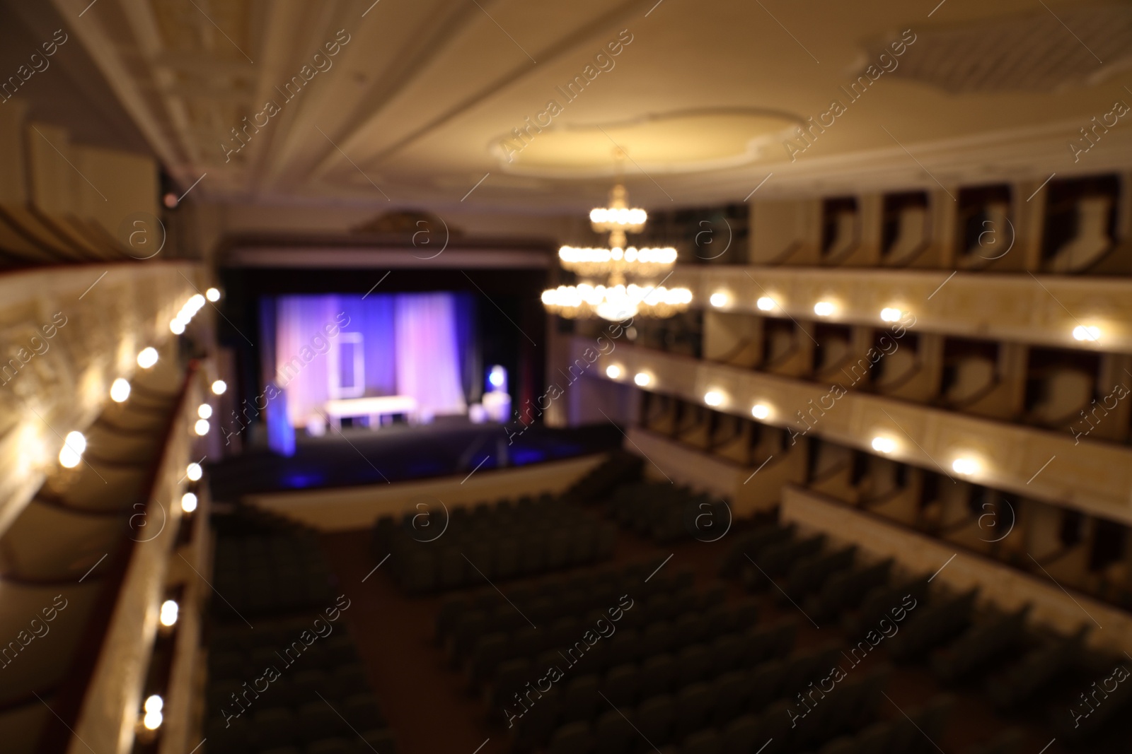 Photo of Theatre interior with stage, rows of comfortable seats and beautiful chandelier