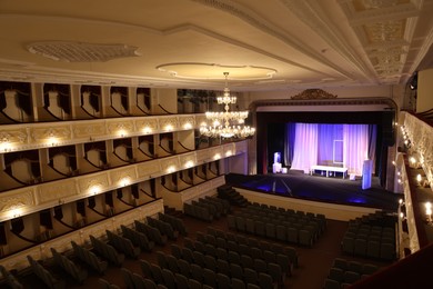 Theatre interior with stage, rows of comfortable seats and beautiful chandelier