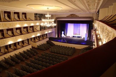 Theatre interior with stage, rows of comfortable seats and beautiful chandelier