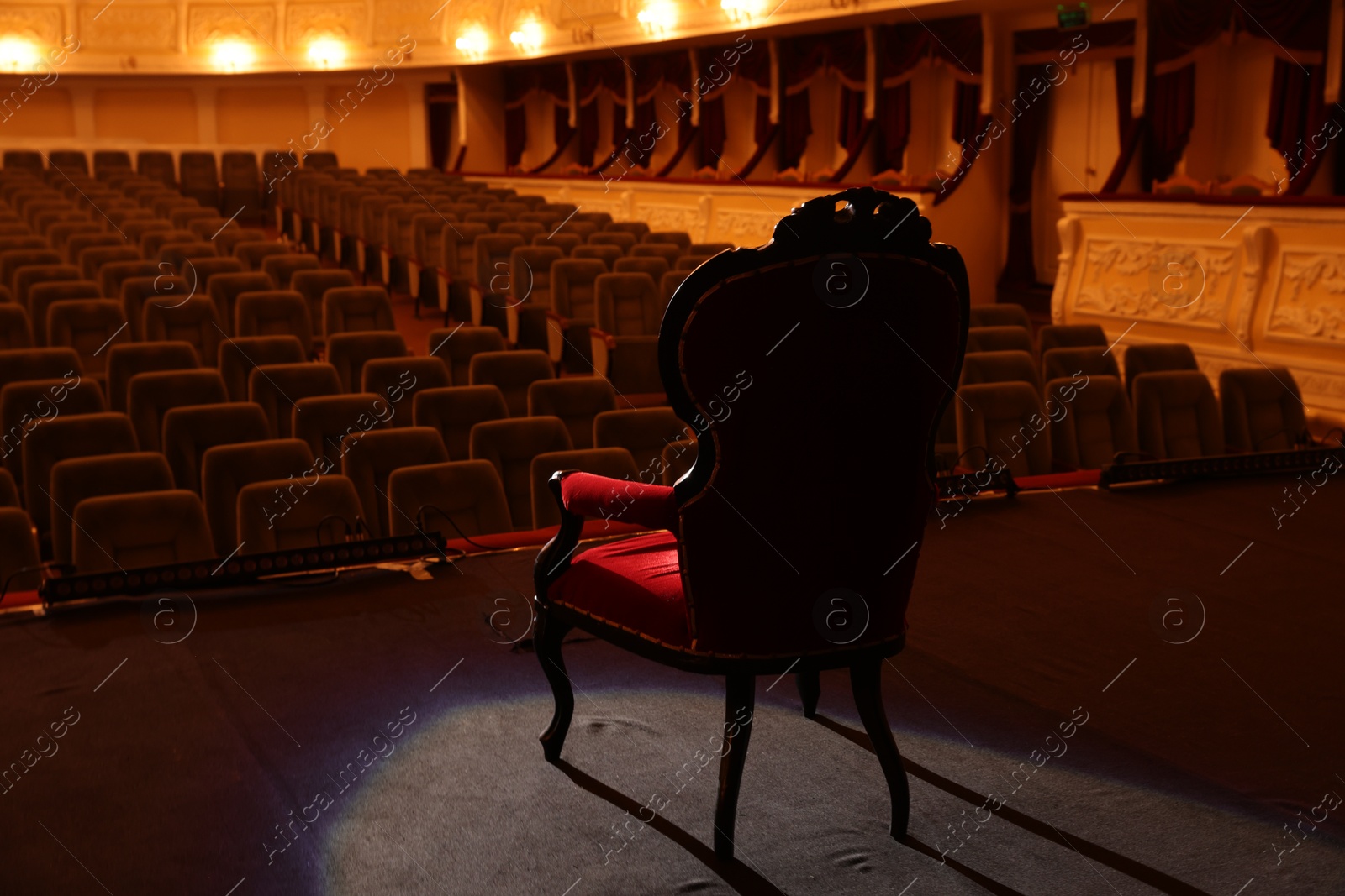 Photo of Vintage red armchair on stage in theatre, back view