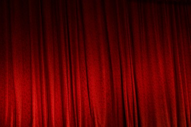 Photo of Elegant red curtains in theatre as background, closeup