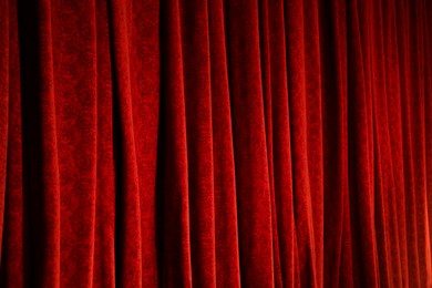 Photo of Elegant red curtains in theatre as background, closeup