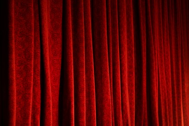 Photo of Elegant red curtains in theatre as background, closeup