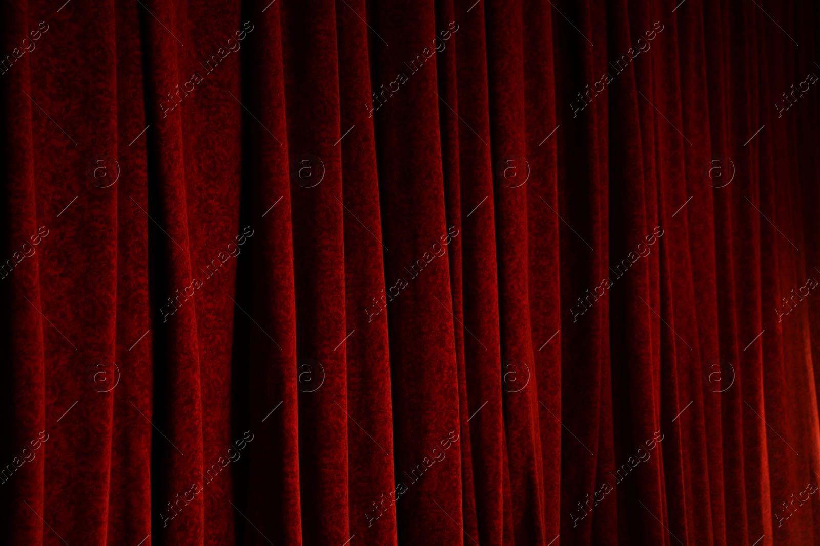 Photo of Elegant red curtains in theatre as background, closeup