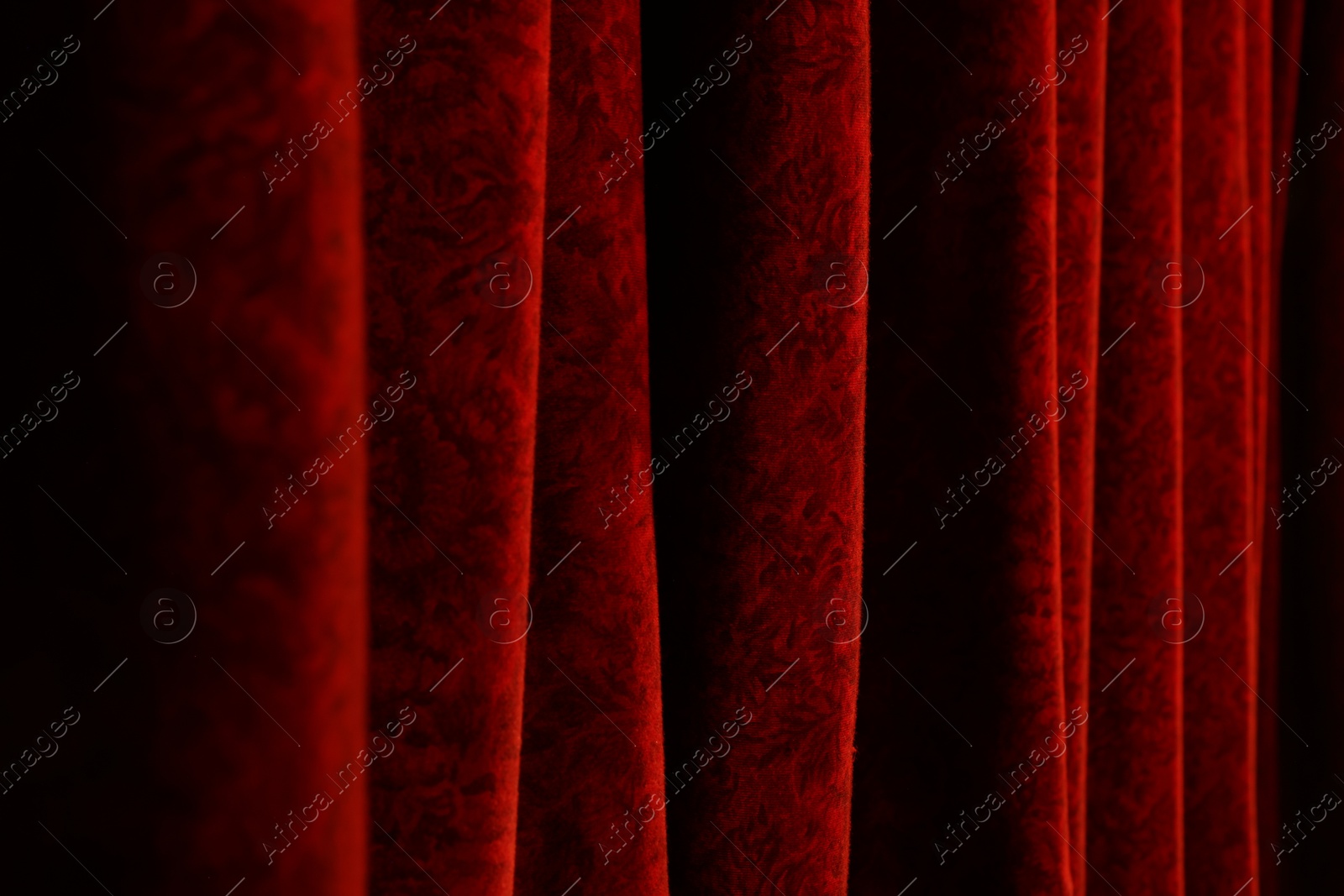 Photo of Elegant red curtains in theatre as background, closeup