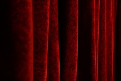 Photo of Elegant red curtains in theatre as background, closeup