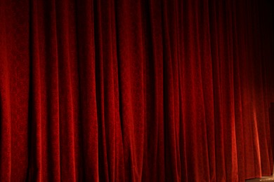 Photo of Elegant red curtains in theatre as background, closeup