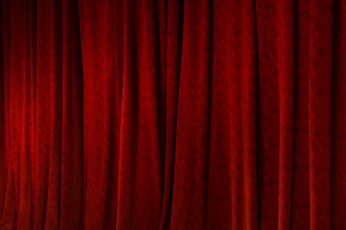 Photo of Elegant red curtains in theatre as background, closeup