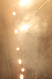 Photo of Professional spotlights and smoke on stage in theatre