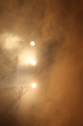 Photo of Professional spotlights and smoke on stage in theatre