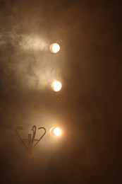 Photo of Professional spotlights and smoke on stage in theatre