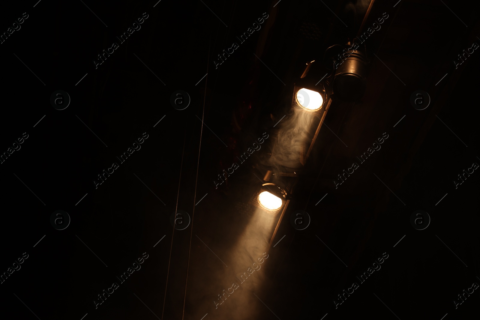 Photo of Professional spotlights and smoke on stage in theatre