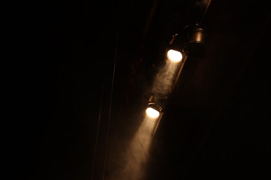 Photo of Professional spotlights and smoke on stage in theatre