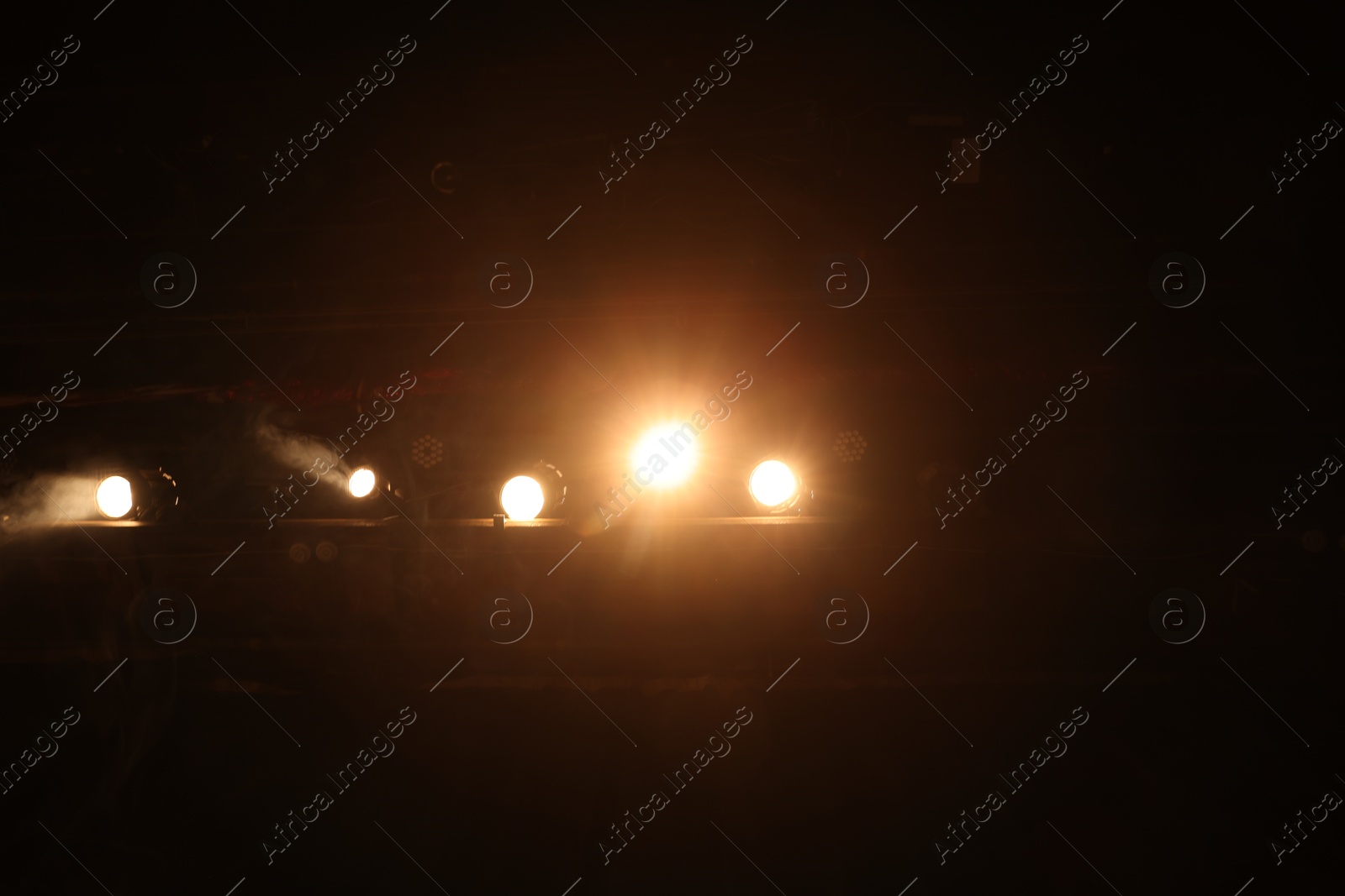 Photo of Bright professional spotlights on stage in theatre