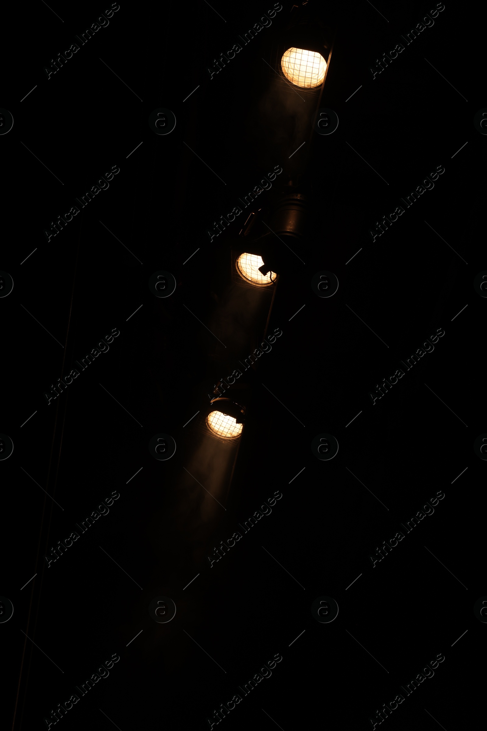 Photo of Professional spotlights against dark background in theatre