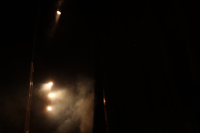 Photo of Professional spotlights and smoke on stage in theatre