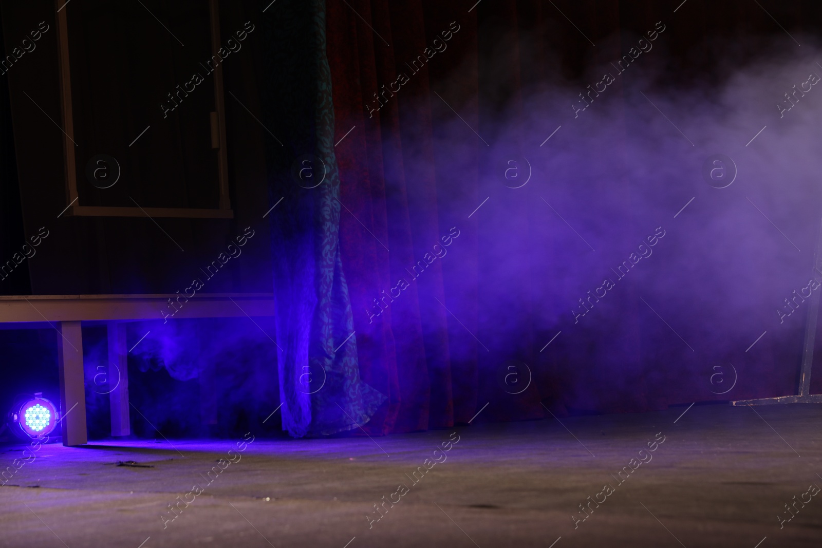 Photo of Professional spotlight and smoke on stage in theatre