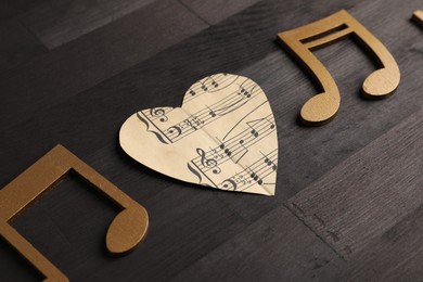 Paper heart and notes on black wooden table, closeup