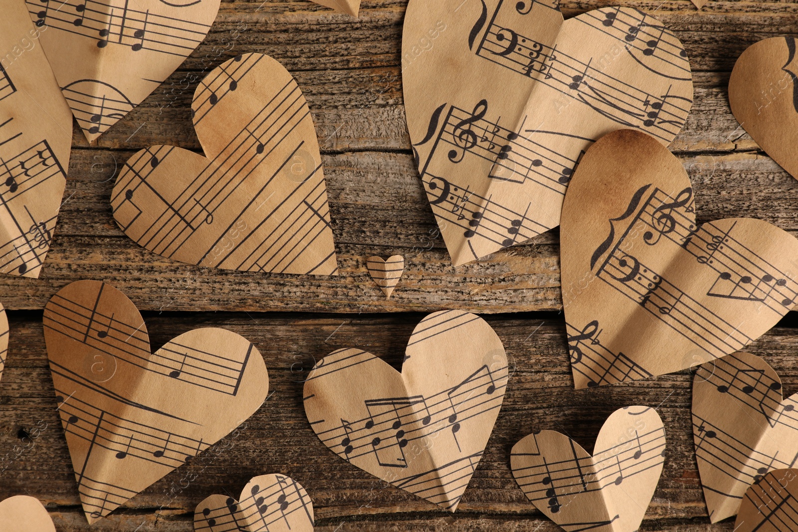 Photo of Paper hearts with notes on wooden table, flat lay