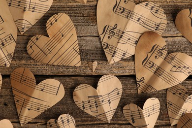 Paper hearts with notes on wooden table, flat lay