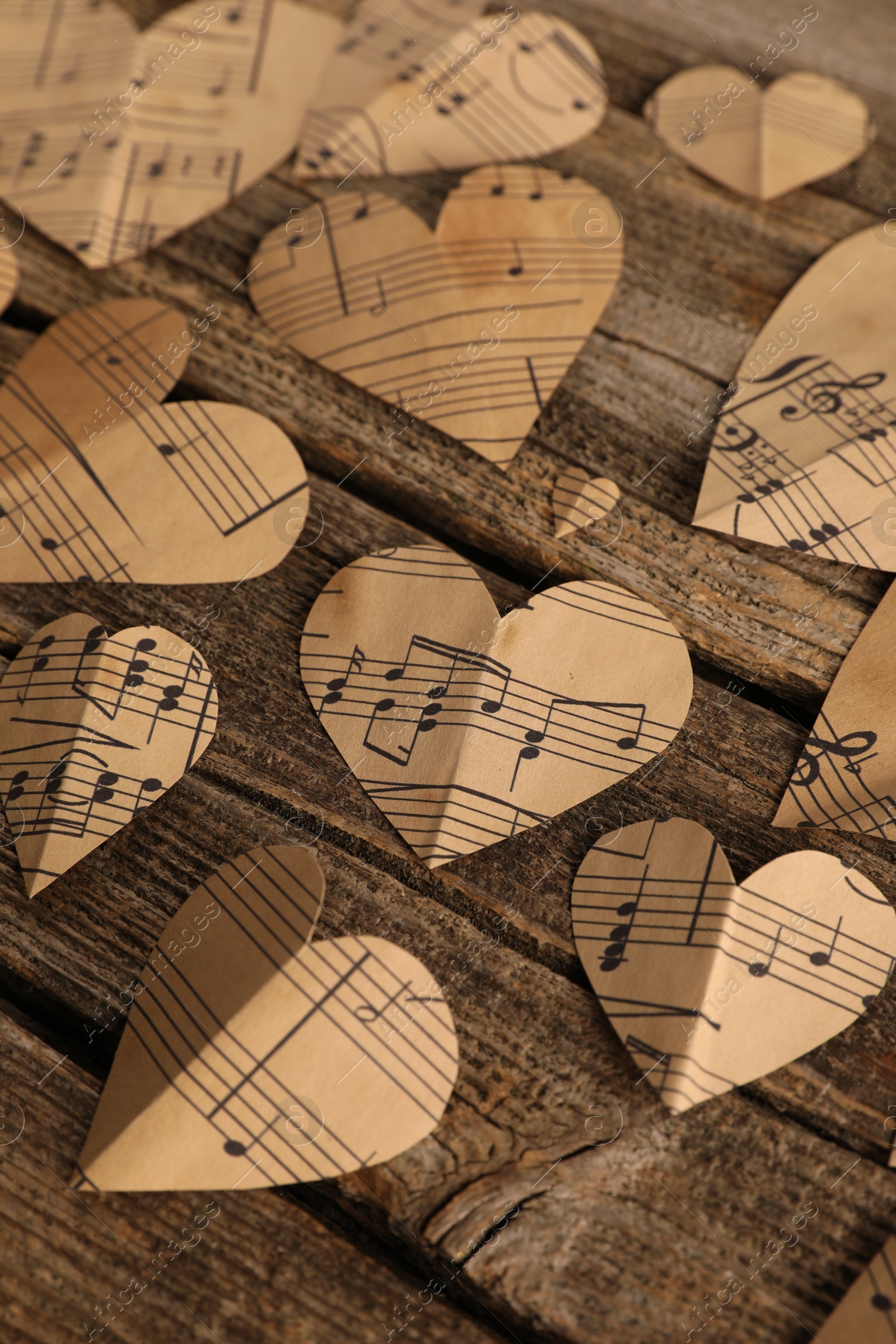 Photo of Paper hearts with notes on wooden table, closeup