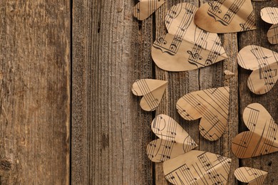 Paper hearts with notes on wooden table, flat lay. Space for text