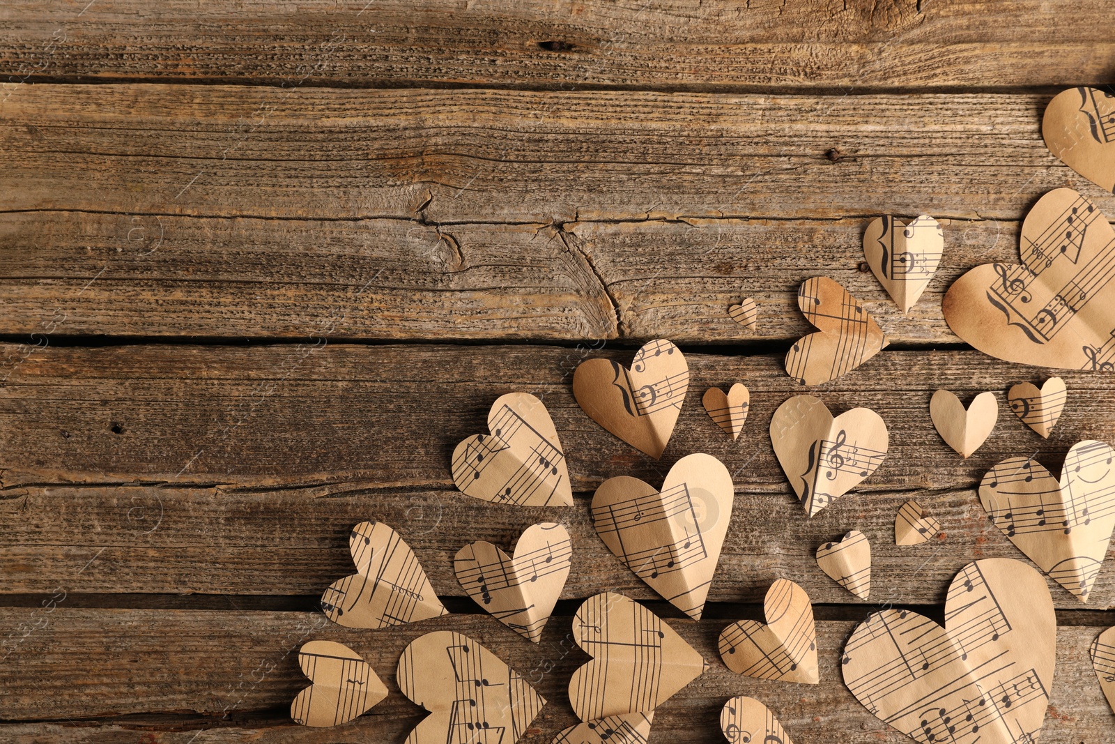 Photo of Paper hearts with notes on wooden table, flat lay. Space for text