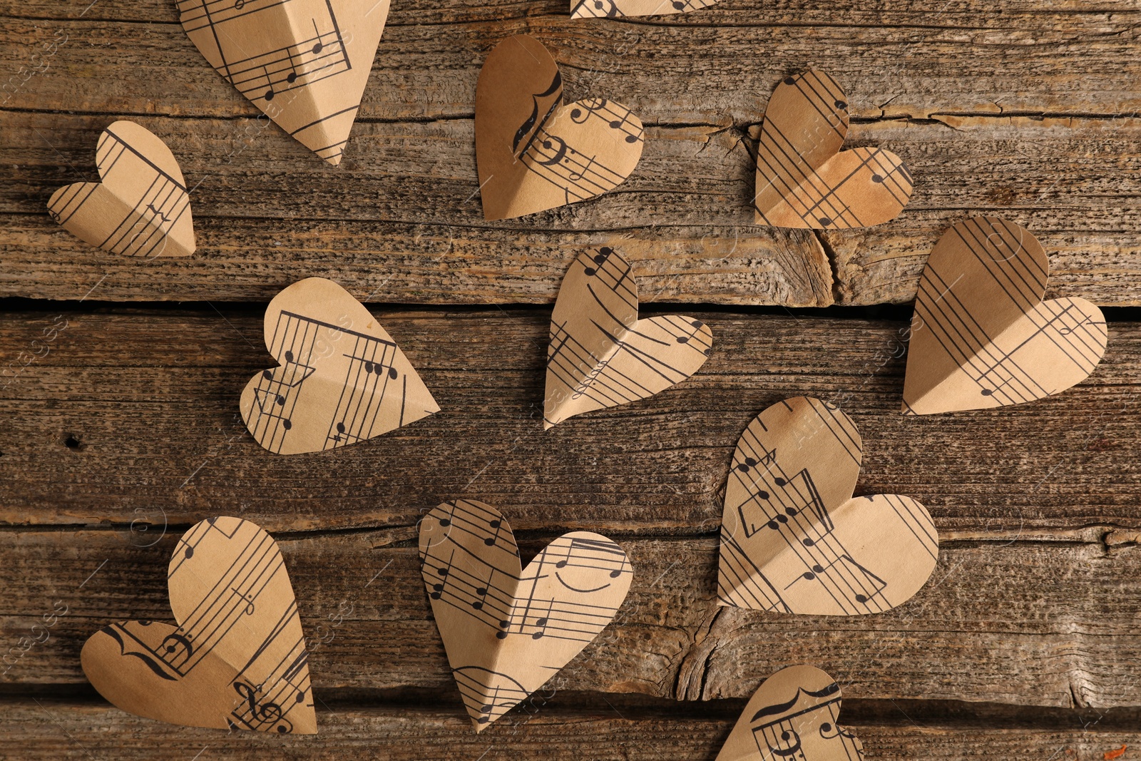 Photo of Paper hearts with notes on wooden table, flat lay