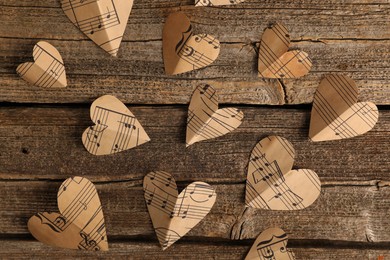 Paper hearts with notes on wooden table, flat lay