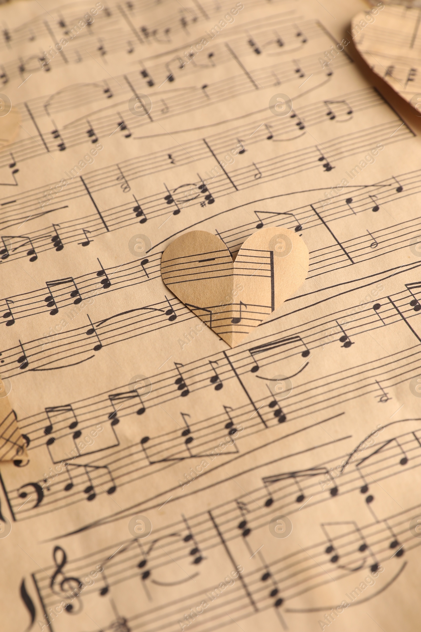 Photo of Paper hearts with notes on musical note sheet, closeup