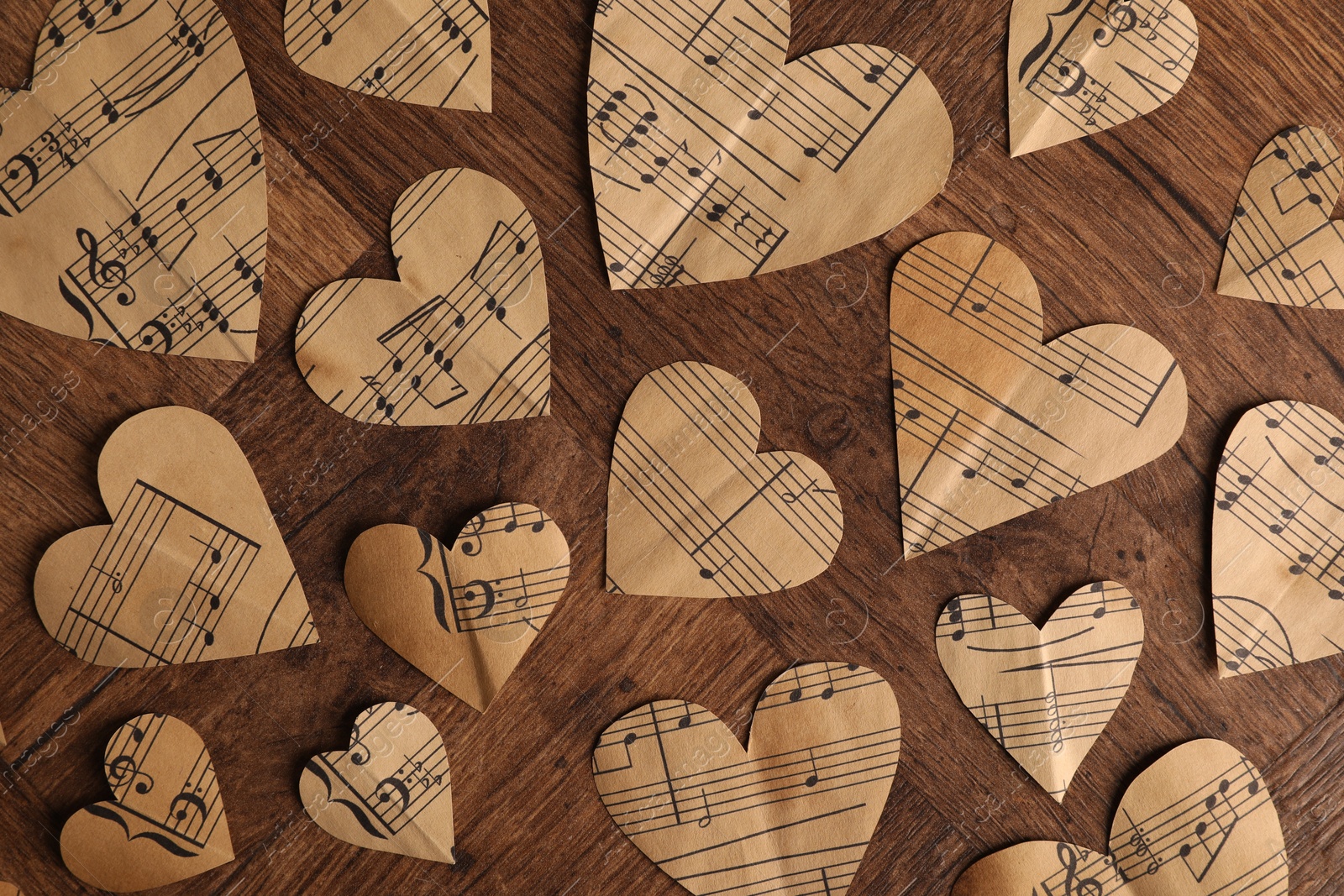 Photo of Paper hearts with notes on wooden table, flat lay