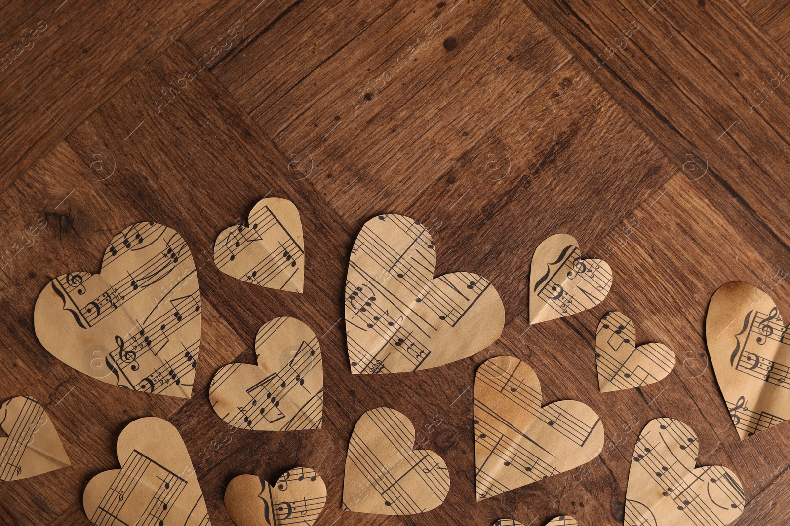 Photo of Paper hearts with notes on wooden table, flat lay. Space for text