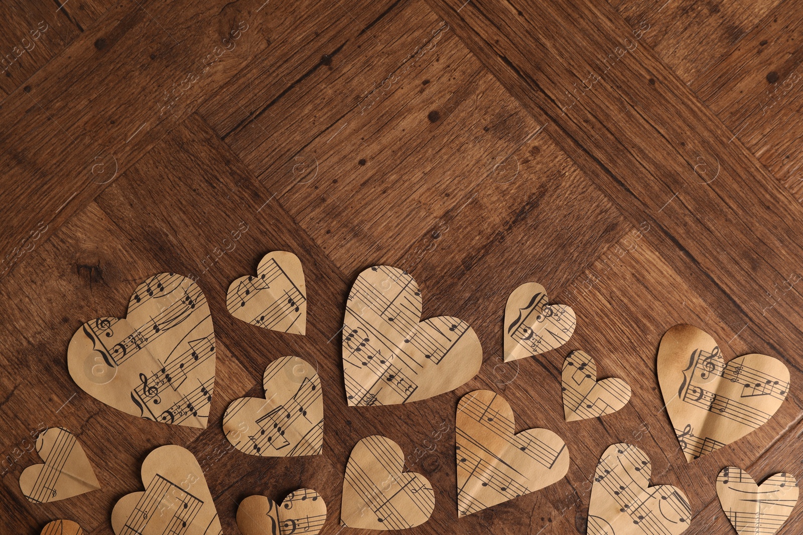 Photo of Paper hearts with notes on wooden table, flat lay. Space for text